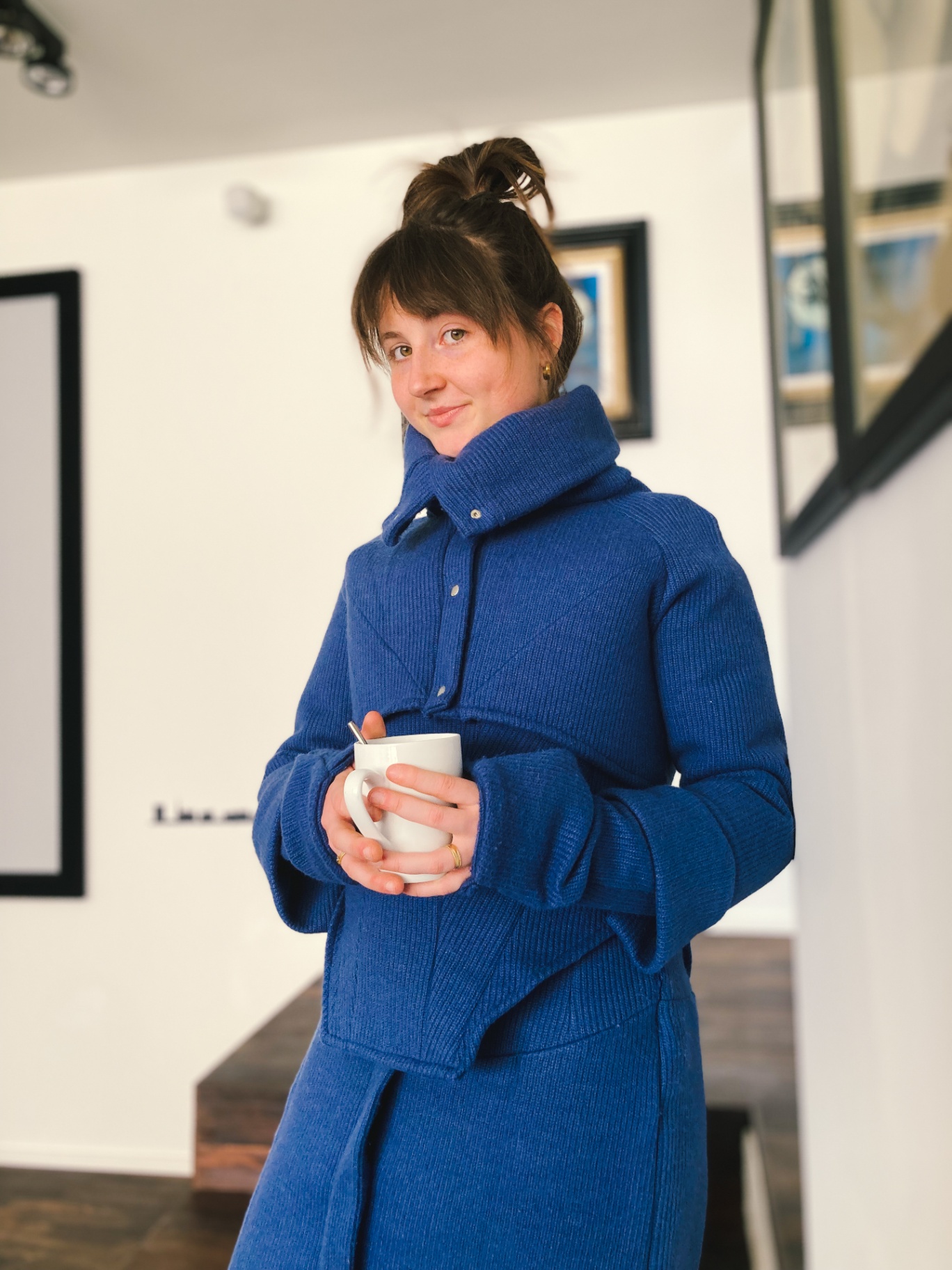 Charlotte holding a mug in the blue Hotcharlie outfit.