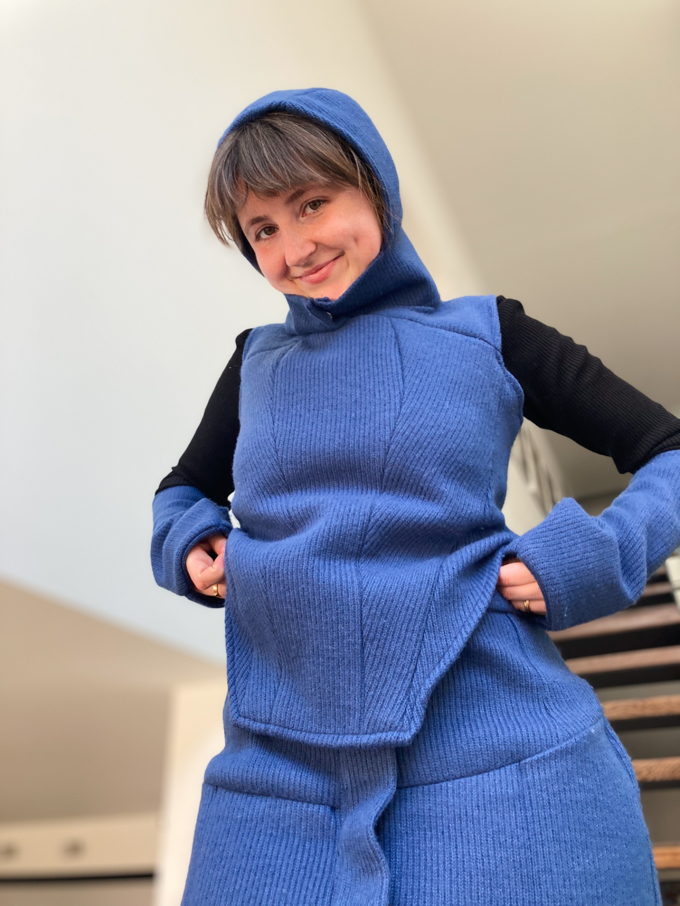 Charlotte on the stairs in the blue Hotcharlie outfit with hood.