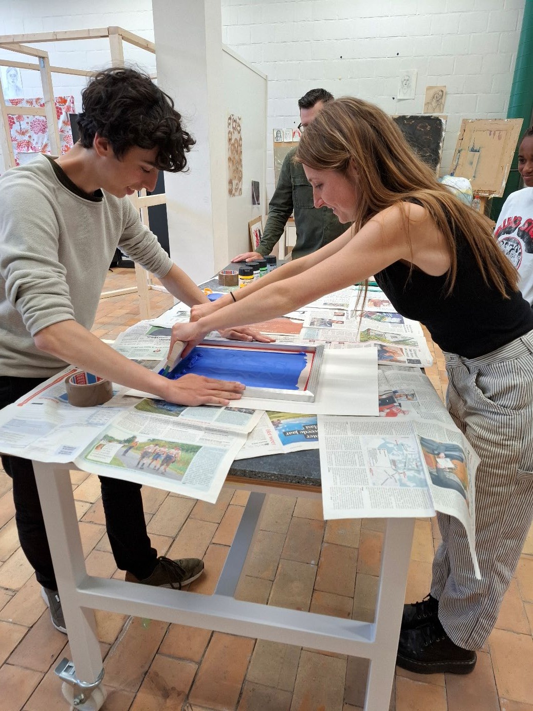 During an evening class, helping a student with screen printing.