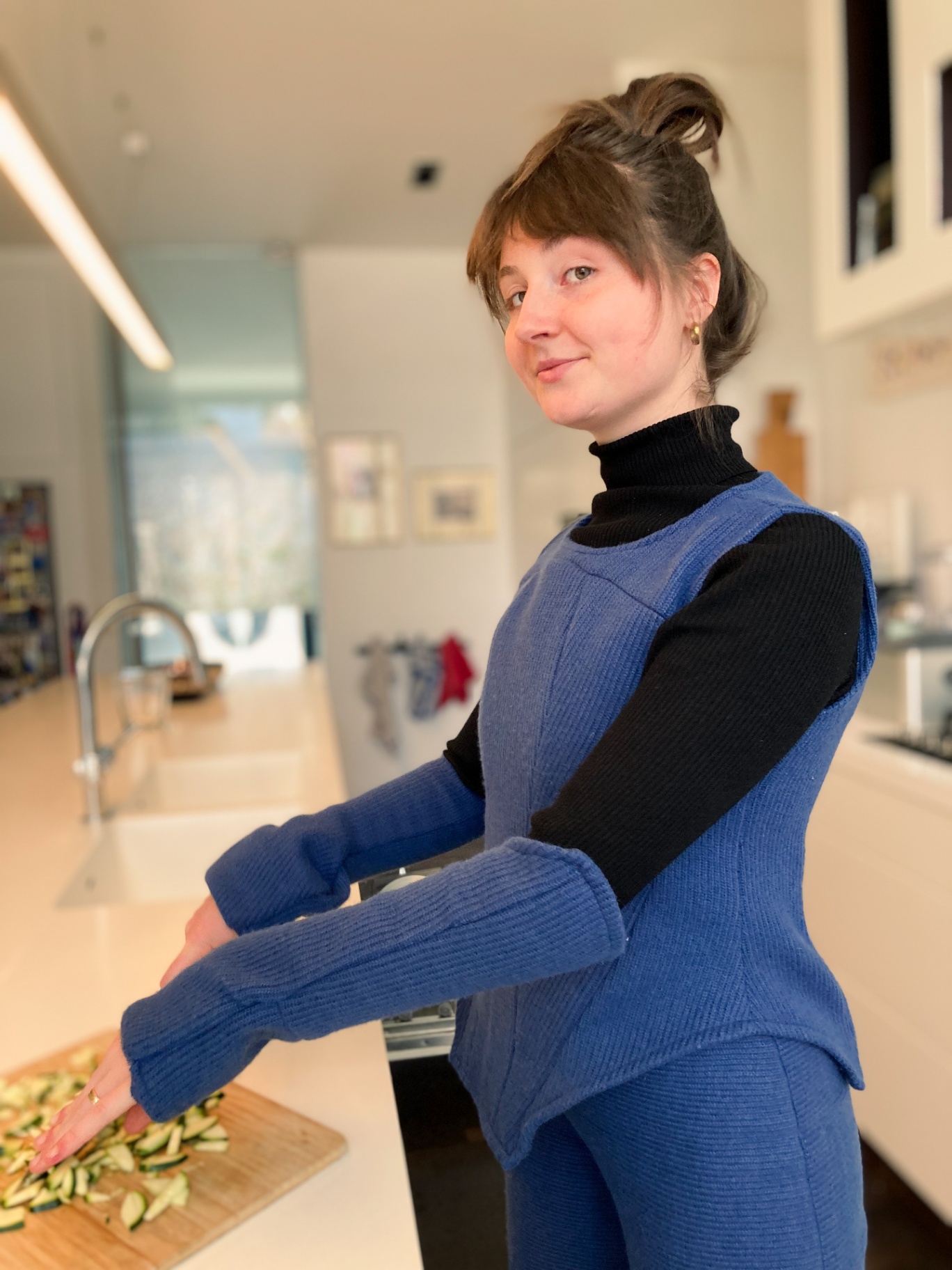 Charlotte cooking in the kitchen wearing the blue Hotcharlie outfit.
